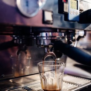 Espresso shot being pulled from coffee machine portafilter