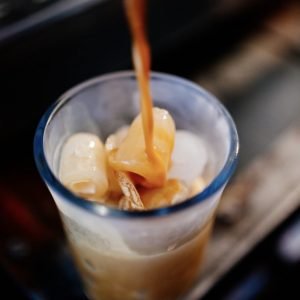 Pouring coffee over ice to make iced coffee