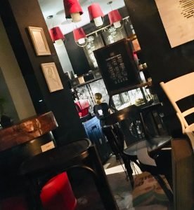 Coffee Circus Porto Msida interior featuring modern industrial design with striking red pendant lights, espresso bar, and contemporary seating area